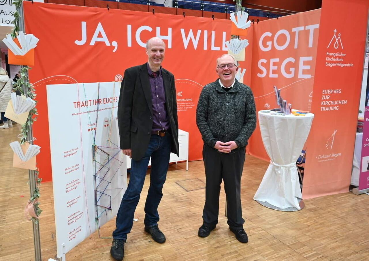 Pfarrer Stefan König (Kirchengemeinde Lukas Siegen) und Pfarrer Friedhelm Rüsche (Pastoralverbund Nördliches Siegerland am ökumenischen Stand.